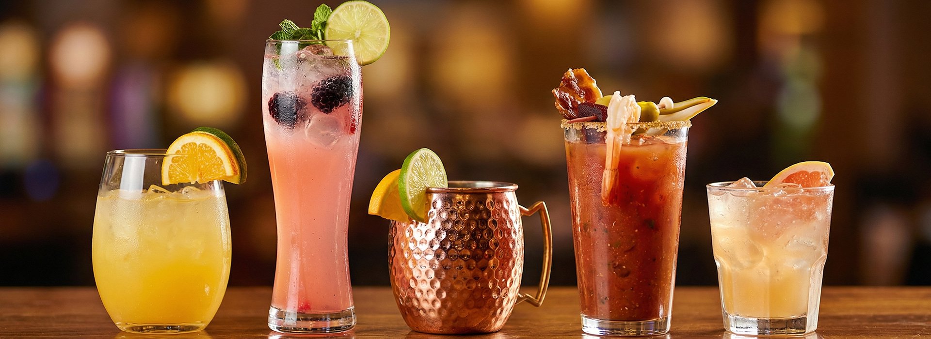An arrangement of cocktails on a bar top.