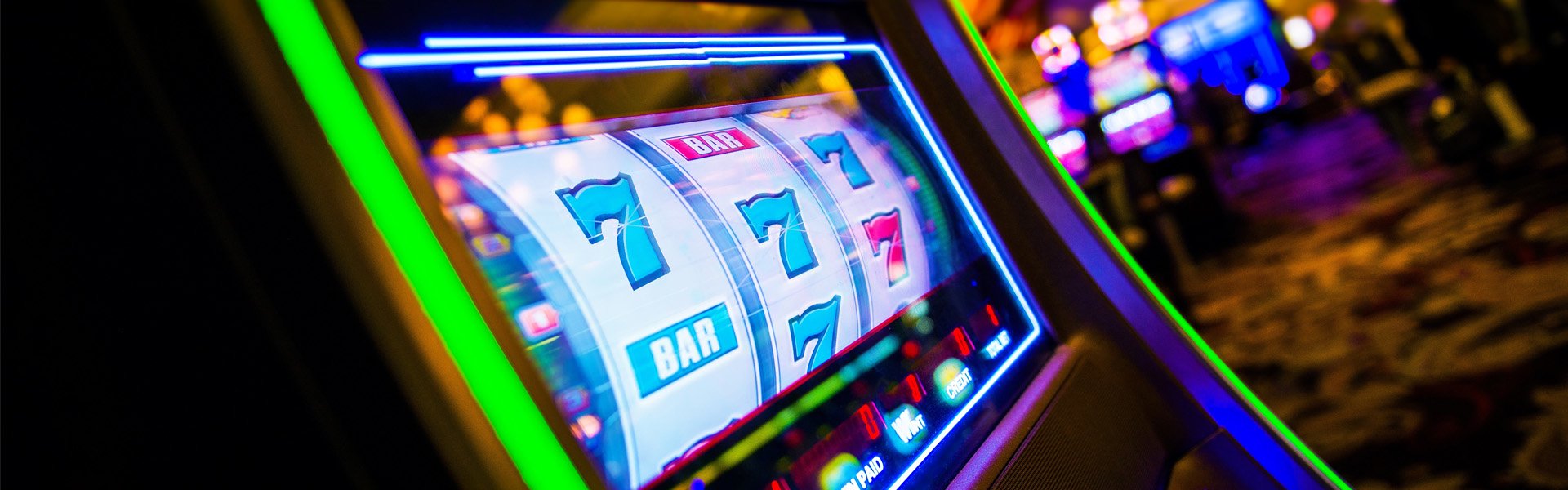 Close‑up of a brightly lit slot machine with sevens and bar symbols at Happy Valley Casino in State College, Pennsylvania.