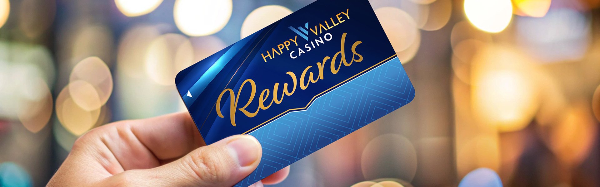 Hand holding a Happy Valley Casino Rewards card against a warm, blurred background in State College, Pennsylvania.