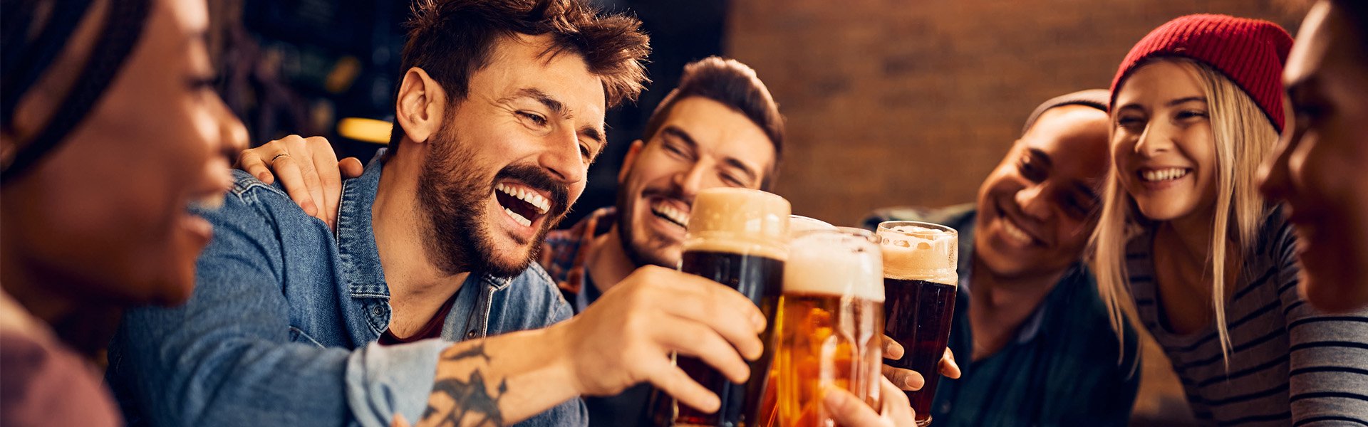 Group of friends raising beer glasses in a celebratory toast at Happy Valley Casino in State College, Pennsylvania.